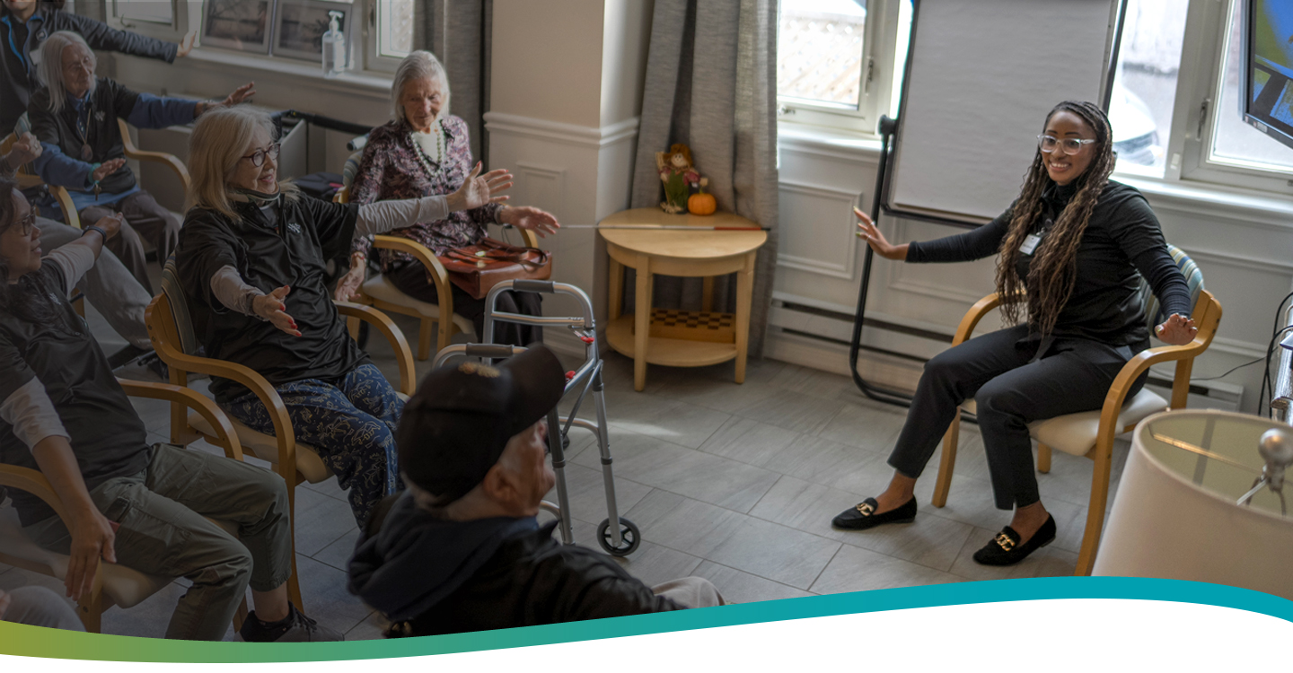 Life Enrichment Director engaging residents in a group exercise activity at Atrium Retirement Residence in Orillia.
