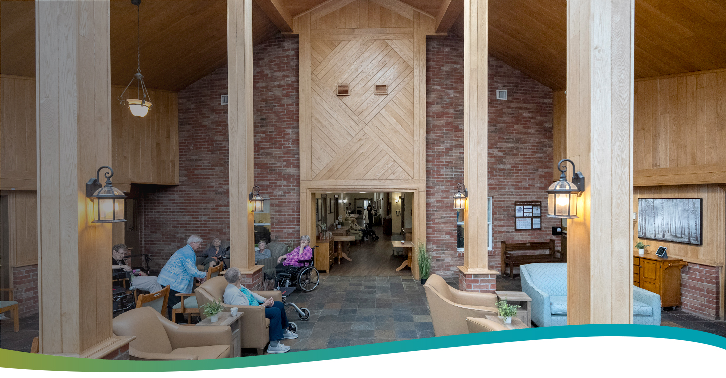 Residents spending time together in the bright atrium shared space with high ceilings at Atrium Retirement Residence in Orillia.