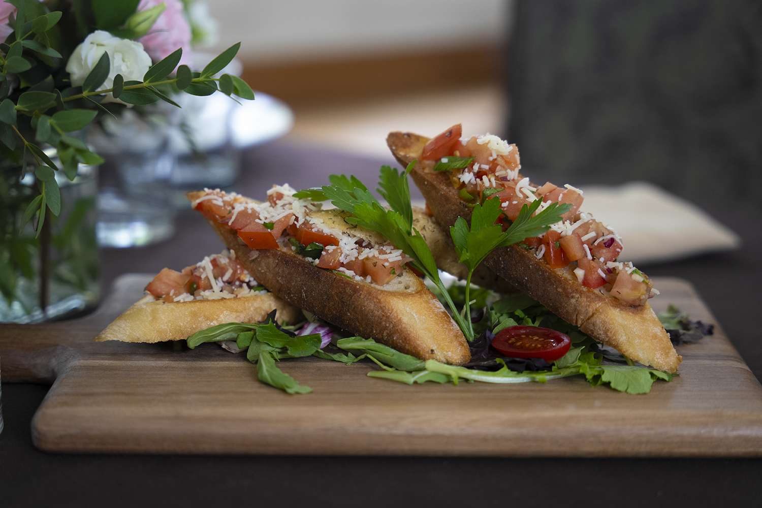 wooden serving board with pieces of fresh bruschetta appetizer